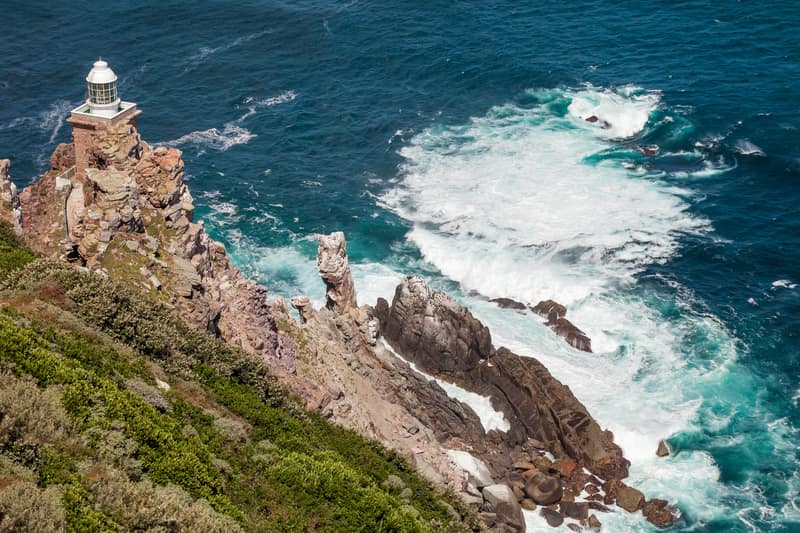 Ein Leuchtturm auf Felsen über der Brandung